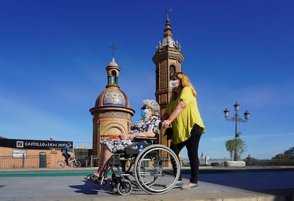 Dos mujeres protegidas con mascarillas junto a la Capillita del Carmen en Sevilla el 2 de mayo