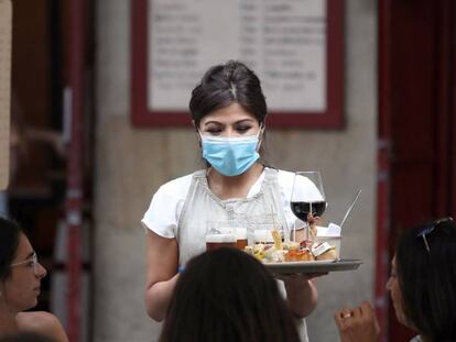 Una camarera atiende a unos turistas este martes en Bilbao.