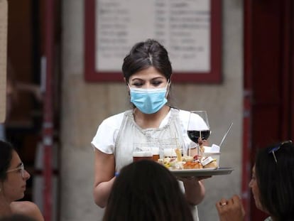 Una camarera atiende a unos turistas este martes en Bilbao.