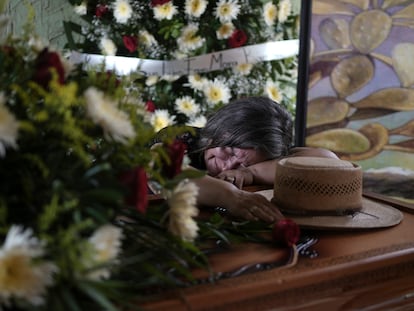 Olivia Mora llora sobre el féretro de su hermano Hipólito Mora, en su casa en La Ruana, el pasado 30 de junio.