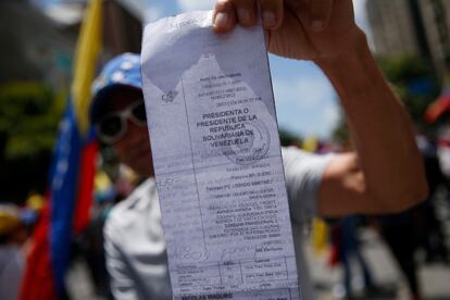 Una manifestante muestra una copia de los registros electorales.