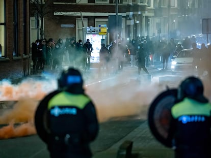Policías antidisturbios, ante grupos de jóvenes, este lunes en Róterdam.