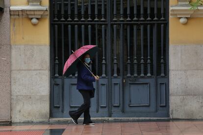 Mulher passa em frente a portão.