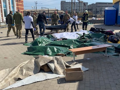 Varios uniformados y ciudadanos trasladaban este viernes los cuerpos sin vida de las víctimas del ataque contra la estación de tren de Kramatorsk.