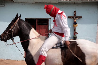 Hombres vestidos de soldados romanos con capucha roja, conocidos como 'espías', participan hoy en el ritual de la aprehensión de Jesús de Nazaret en el poblado de Tzintzuntzan, estado de Michoacán.