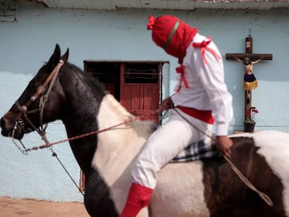 Hombres vestidos de soldados romanos con capucha roja, conocidos como 'espías', participan hoy en el ritual de la aprehensión de Jesús de Nazaret en el poblado de Tzintzuntzan, estado de Michoacán.