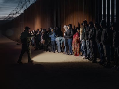 Migrantes junto al muro fronterizo en San Diego, California, en diciembre de 2023.