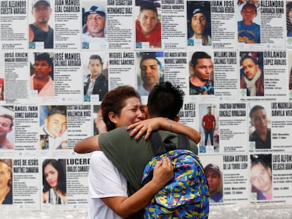 Una mujer abraza a su hijo frente a un mural con información de personas desaparecidas, en Guadalajara (México).