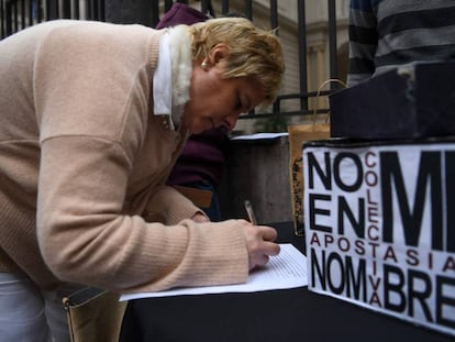Una mujer completa la petición de apostasía frente a la Conferencia Episcopal Argentina.
