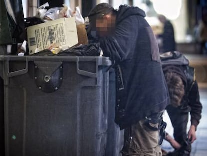 Una persona busca comida en un contenedor pr&oacute;ximo a un restaurante del centro de Barcelona