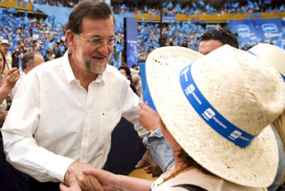 El líder del PP saluda a una simpatizante en el acto de su partido en Zaragoza.