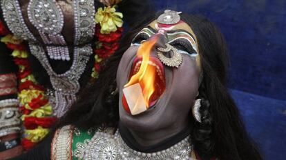 Un hombre indio vestido de la diosa hindú Kali realiza una actuación con fuego durante una procesión para conmemorar el festival Mahashivratri en Allahabad (India).