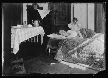 Una niña junto a su hermana, enferma, durante la pandemia de 1918