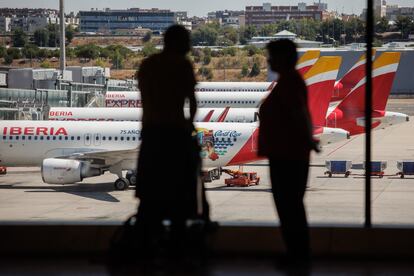 Dos personas ante un ventanal de la T4 del aeropuerto Adolfo Suárez Madrid-Barajas.
