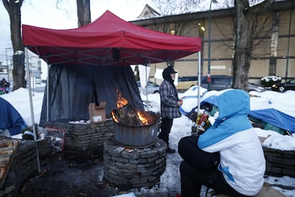 Tras una fuerte nevada, varias personas sin hogar se reúnen en torno a una hoguera en el Parque Oppenheimer de Vancouver, Canadá, en abril de 2020.