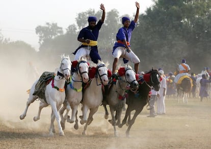 Unos guerreros de la tribu de los 'Nihang', orden perteneciente a la religión monoteísta Nihang, realizan una exhibición subidos a un grupo de caballos durante una procesión del festival 'Hola Mohalla' en Amritsar, India.