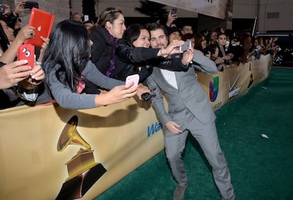 El cantante Juanes se hace fotos con sus fans en la alfombra de los Premios Grammys Latinos.