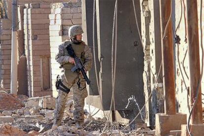 Un <i>marine</i> patrulla hoy junto a un edificio destrozado en la ciudad iraquí de Faluya.