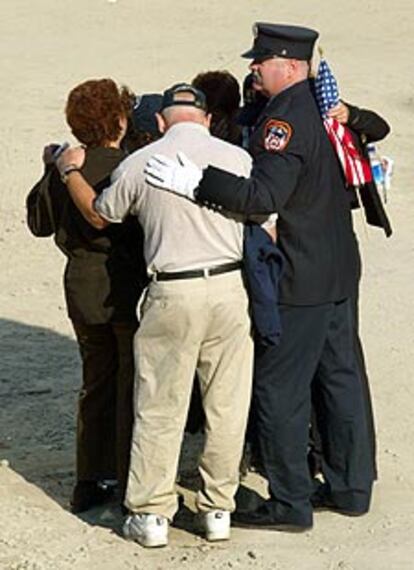 Un bombero de Nueva York abraza a sus familiares en la Zona Cero.