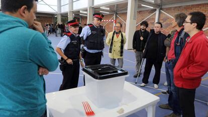Dos mossos ante una urna de un colegio durante la jornada del referéndum del 1 de octubre en Cataluña.