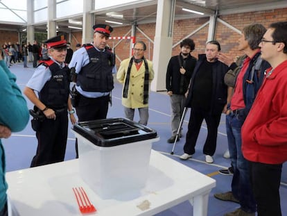 Dos mossos ante una urna de un colegio durante la jornada del referéndum del 1 de octubre en Cataluña.