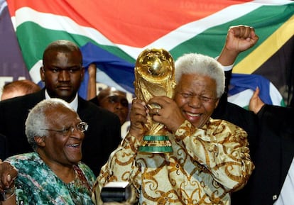 Desmond Tutu y Nelson Mandela, que sujeta el trofeo Jules Rimet que se otorga al campeón del mundo de fútbol, el 26 de junio de 2013 en Ciudad del Cabo, meses antes del fallecimiento del mandatario. Sudáfrica organizó la competición tres años antes.