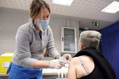 Una sanitaria vacuna a una mujer en Cataluña.