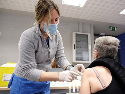 Una sanitaria vacuna a una mujer en Cataluña.