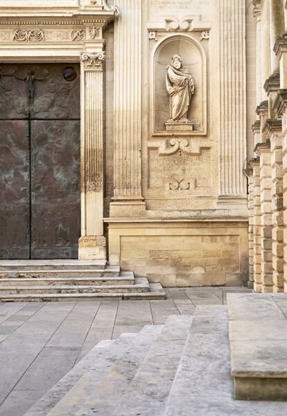 La piedra de Lecce, caliza y clara, se emplea en toda la península salentina porque aligera la presencia de los edificios y contribuye a multiplicar la luz de la ciudad. La catedral de Lecce —en la foto se muestra un detalle de una de sus fachadas— y el palacio neoclásico donde se encuentra este piso comparten el mismo material.