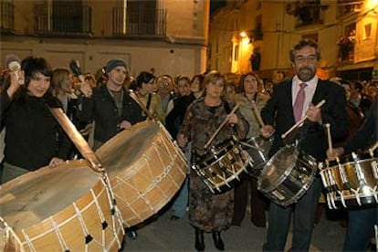 Caras famosas en La Puebla de Híjar: el dúo Amaral (izq.) y el ex ministro socialista Juan Alberto Belloch (dcha.) han participado en la rito de <i>romper la hora</i> que se celebra cada Semana Santa en la localidad turolense.