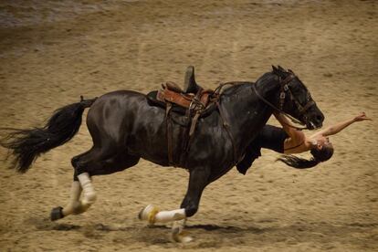 Una mujer durante la exhibición de volteo acrobático a caballo.