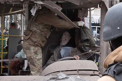 Un militar ucraniocubre con una chaqueta el cuerpo sin vida de un aconductora de trolebús tras el ataque con misiles rusos en Sumi.
