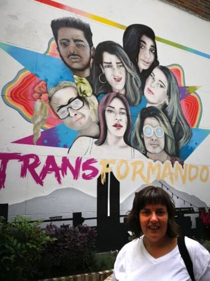 Natalia Aventín, madre de Patrick, junto a un cartel sobre transexualidad del centro LGTBI de Medellín (Colombia).