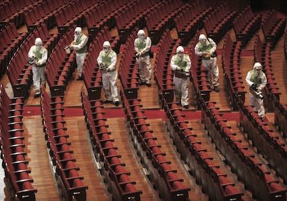 Workers wearing protective gears, spray antiseptic solution as a precaution against the spread of MERS, Middle East Respiratory Syndrome, virus at the Sejong Culture Center in Seoul, South Korea, Tuesday, June 16, 2015. The outbreak of the poorly understood disease has caused widespread fear in South Korea and criticism that health workers and the government failed to initially recognize and quickly contain it. (AP Photo/Ahn Young-joon)