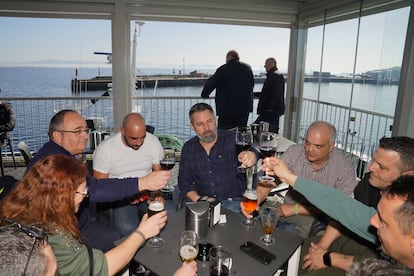 El líder de VOX, Santiago Abascal (centro), y el candidato de VOX en A Coruña, Manuel Fuentes (segundo por la derecha), toman unas copas con pescadores y mariscadores del puerto de Ribeira, el 3 de febrero. 
