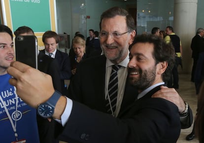 El presidente del Gobierno, Mariano Rajoy, se hace una foto con unos jovenes a su llegada.