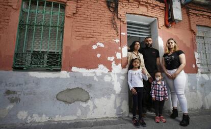 La familia, fotografiada frente a la puerta de su vivienda, en Vallecas. 