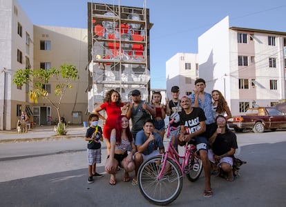 Jovens da Vetinflix em frente ao mural que está sendo pintado em homenagem à paródia "La Casa Duz Vetim".