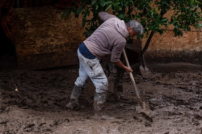 Las lluvias de los últimos días han sido las más fuertes de los últimos 30 años, causando inundaciones, aislando comunidades y cobrando hasta este lunes, dos vidas. En la imagen, un vecino de la comuna de Coltauco en la Región de O'Higgins trabaja con una pala para remover el barro que ha cubierto el sitio, el 26 de junio.