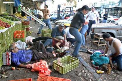 Varios civiles ayudan a los heridos momentos después del atentado en el mercado de Hadera.
