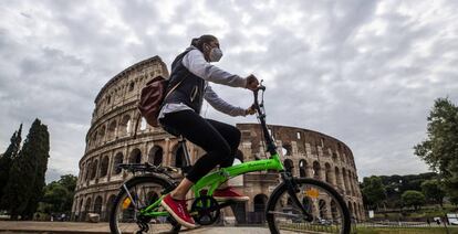 Una ciclista pasa frente al Coliseo romano.