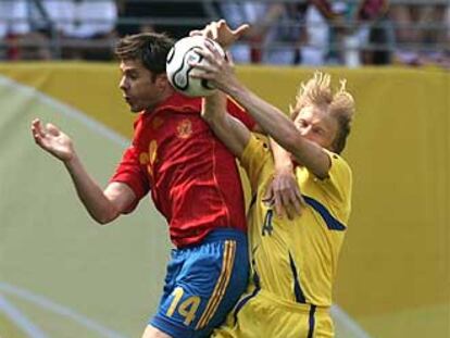 Xabi Alonso se disputa la pelota con Husin.