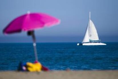 Un catamar&aacute;n navega pr&oacute;ximo a la playa de la Malagueta, en M&aacute;laga.