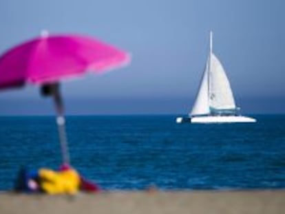 Un catamar&aacute;n navega pr&oacute;ximo a la playa de la Malagueta, en M&aacute;laga.