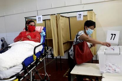 Una mujer acudió en camilla de hospital a emitir su voto en un local electoral de Santiago. 