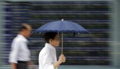 Una mujer se protege del sol (y de lo que caiga) en una calle de Tokio.