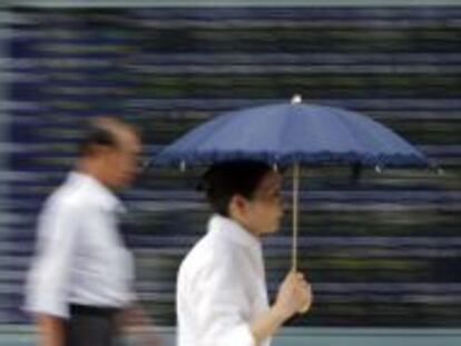 Una mujer se protege del sol (y de lo que caiga) en una calle de Tokio. 