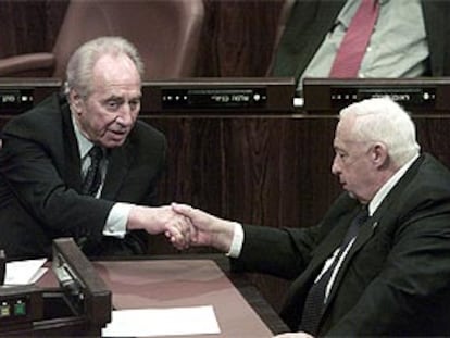 Simon Peres da la mano a Ariel Sharon después de que el parlamento aprobara el plan económico de emergencia.