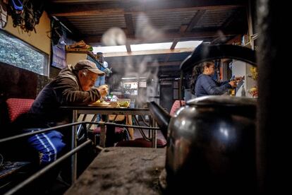 Abraham Morales, de 63 años, come cerca de su esposa Rosa Guinez, de 47, en la cocina de su casa del campamento Pedro del Río Zanartu en Concepción, Chile