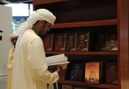 Un hombre lee un libro en la Feria del Libro de Emiratos &Aacute;rabes